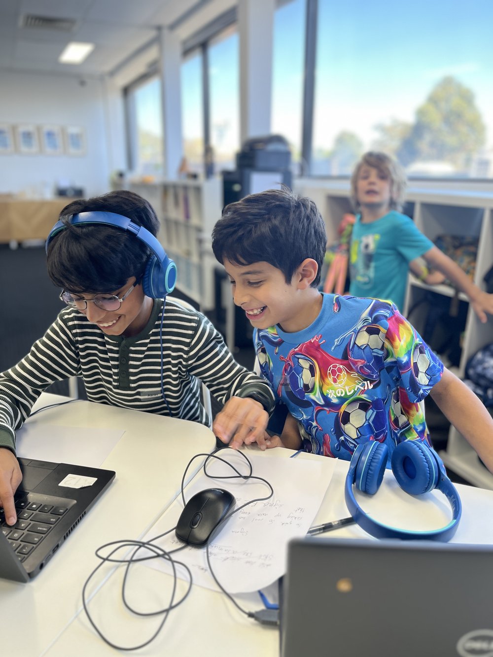 Two students working through a project on a laptop