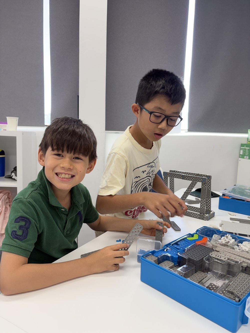 Two students building a robotics kit together
